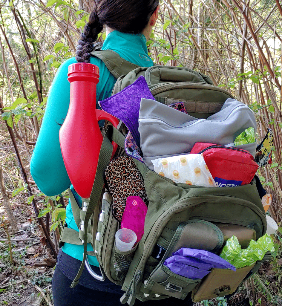 A woman wearing a backpack kit with a variety of femenine hygeine products peeking out