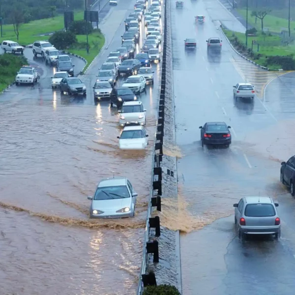 Cars driving a flooded highway.