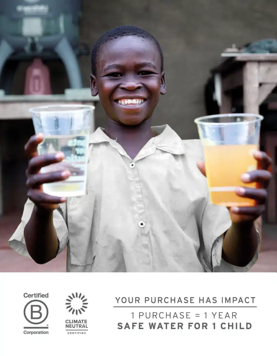 Give Back Program - Boy holding a cup of dirty water beside a cup of clean water