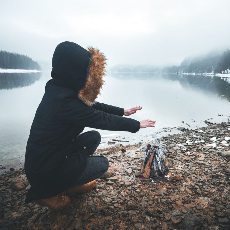 Woman warming hands over fire